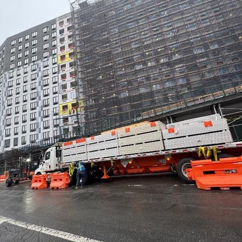 Boom truck delivering sheetrock to an upper floor