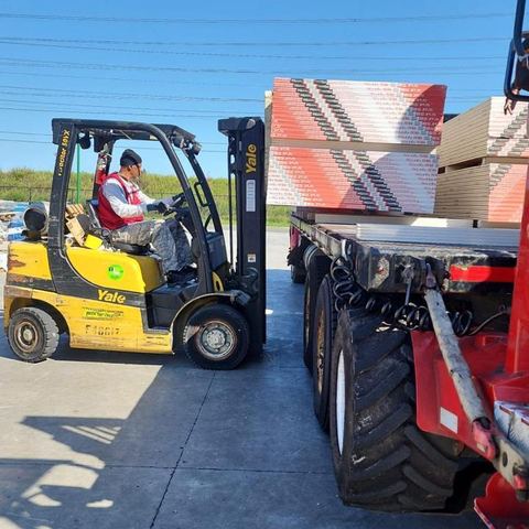 Forklift loading sheetrock in a supplier yard